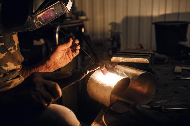 Male in face mask welds with argon welding Industrial welder worker welding using argon machine