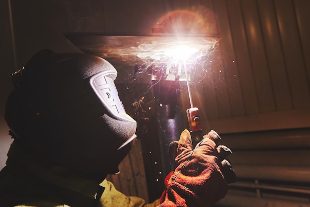 Photo male in face mask welds with welding