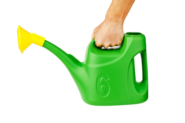 A male farmer's hand holds a green plastic watering can isolated on a white background.