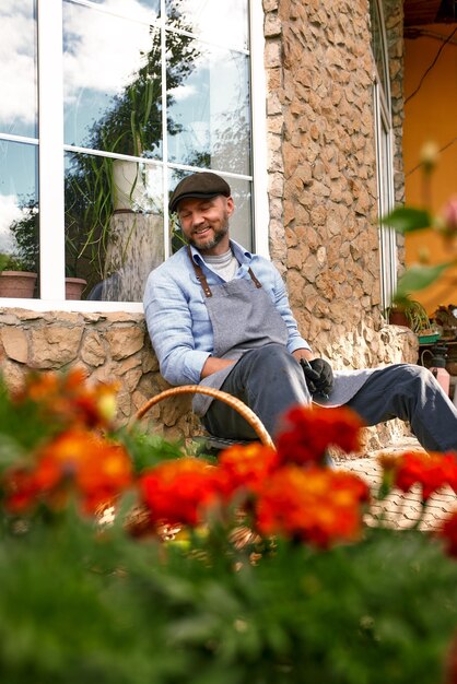 Photo a male farmer sitting in the yard outdoors resting