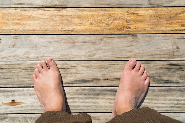 Foto piedi maschili in piedi sul pavimento di legno vista superiore spazio di copia per il testo