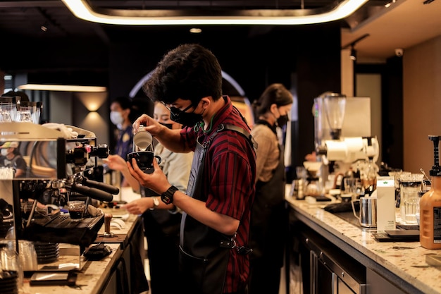 Male and female barista are busy making a coffee at coffee shop