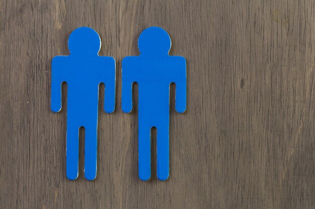 Male and female cutouts on wood background.