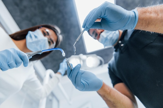 Male and female dentists working in the office together. First person view.