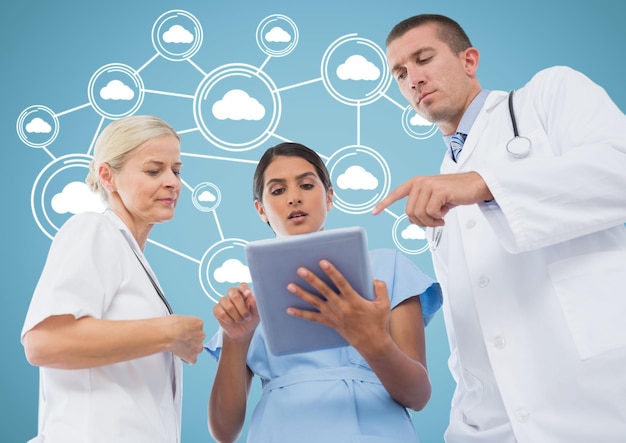 Male and female doctors discussing over digital tablet with cloud computing icons in background