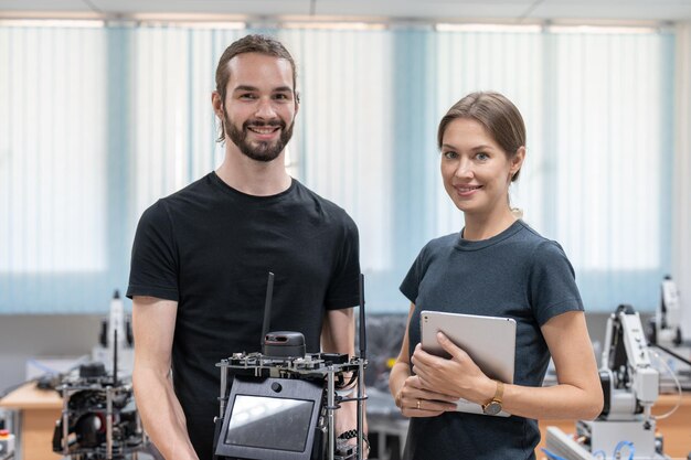 Foto ingegneri maschi e femmine testano e controllano il modello di robot ai nella sala del laboratorio di robotica dell'accademia