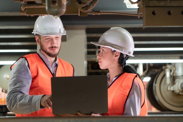 Male and female engineers work together in an electric repair station Inspecting the undercarriage