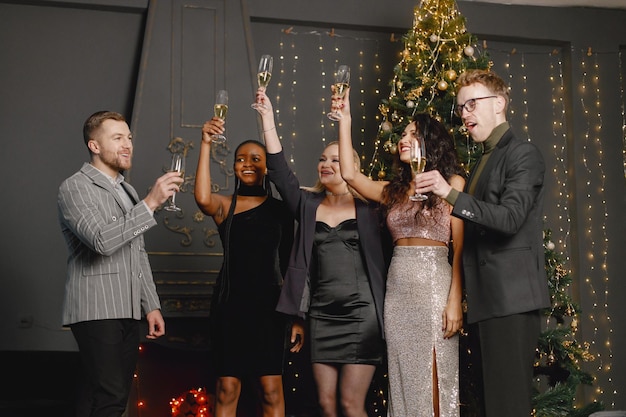 Male and female friends in elegant dresses celebrating New Year