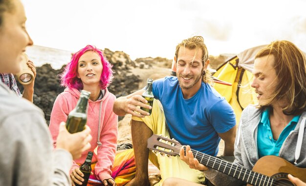 Foto amici maschi e femmine che si godono la musica sulla spiaggia