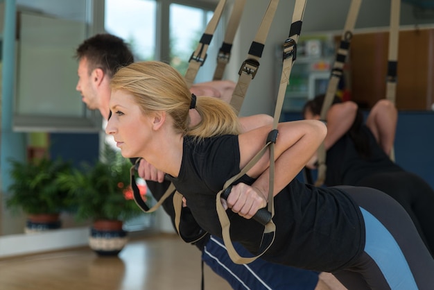 Male and Female Friends Working Out With Trx in Gym