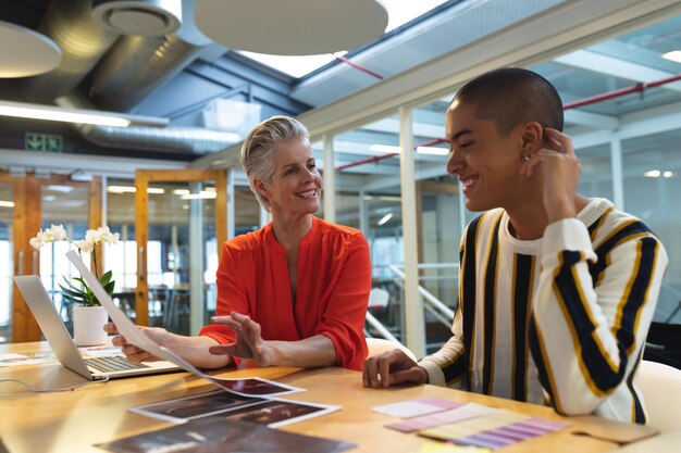 Male and female graphic designers discussing over photographs