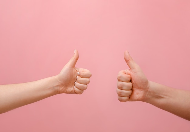 male and female hand on a pink wall