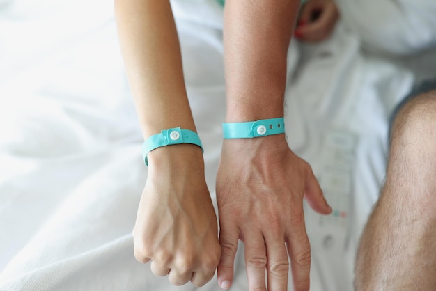 Photo on the male and female hands a blue hotel bracelet