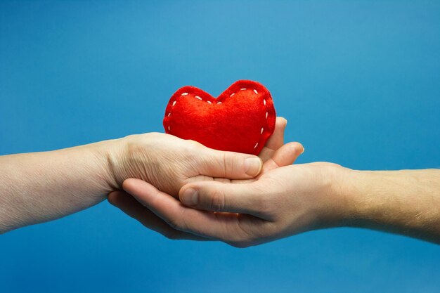 Male and female hands holding a heart