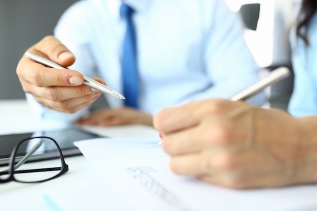 Male and female hands holding pens