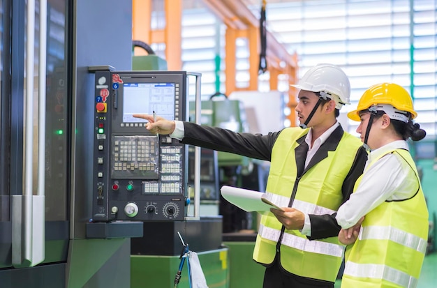 Male and Female Industrial Engineers in Hard hats Discuss Project or working and strategy business