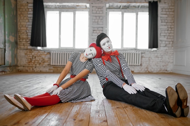 Male and female mime artists sitting on the floor, love couple parody scene, comedy