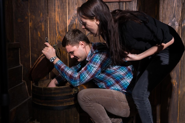 Male and female opened a barrel and trying to solve a conundrum to get out of the trap, escape the room game concept