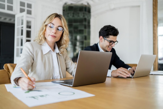 Male and female partner managers are working together on an online startup project They use laptops