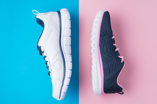 Male and female sport shoes on a pink and blue