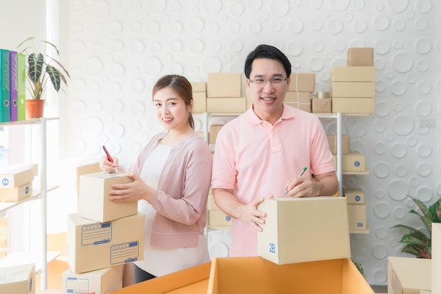 Photo male and female staff writing the address in front of the package to be shipped