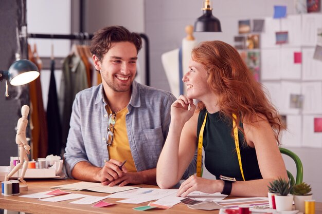 Photo male and female students or business owners working on designs in fashion studio together