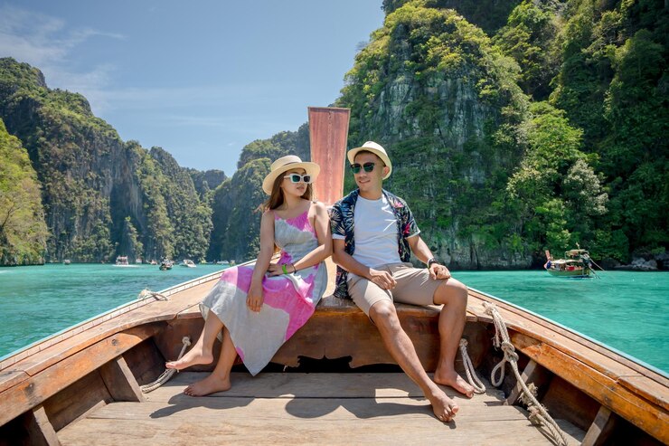 Photo male and female tourists take a longtail boat on a tropical island phi leh island the sea