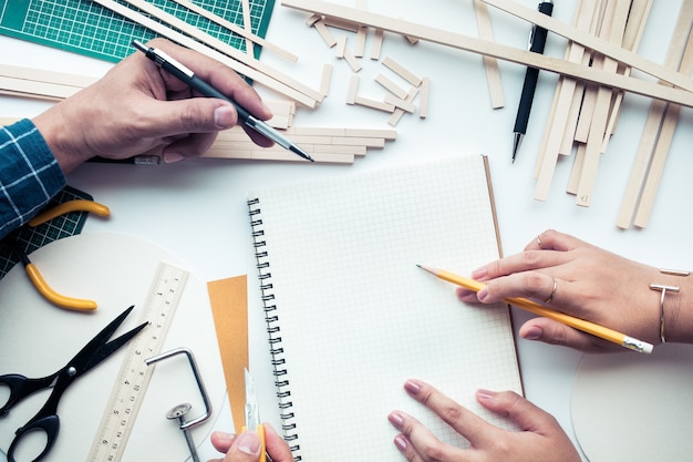 Lavoro maschile e femminile su piano di lavoro con materiale in legno di balsa