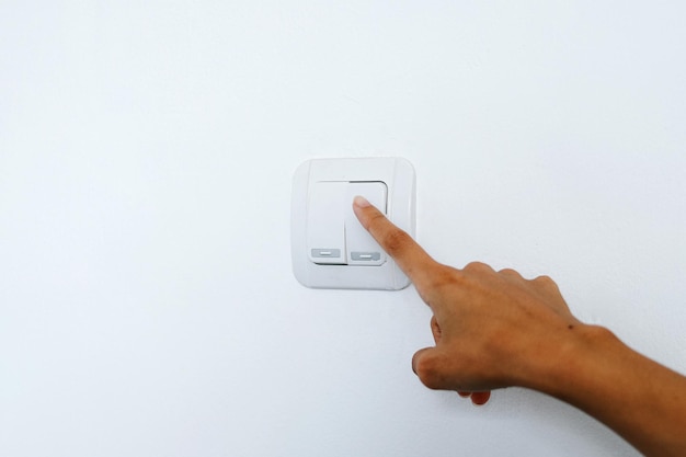 Male finger is turn off lighting switch at home Save energy concept