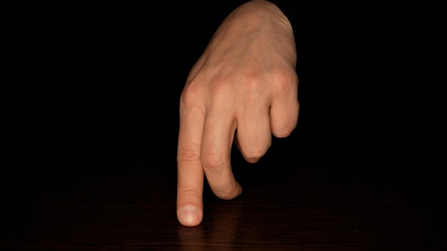 Male fingers dancing on a dark background Fun and theater concept