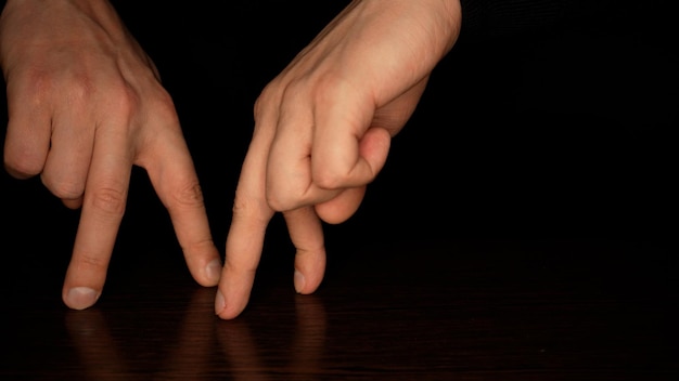 Male fingers dancing on a dark background Fun and theater concept