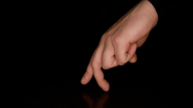 Male fingers dancing on a dark background Fun and theater concept