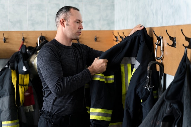 Foto vigile del fuoco maschio che si veste per il lavoro