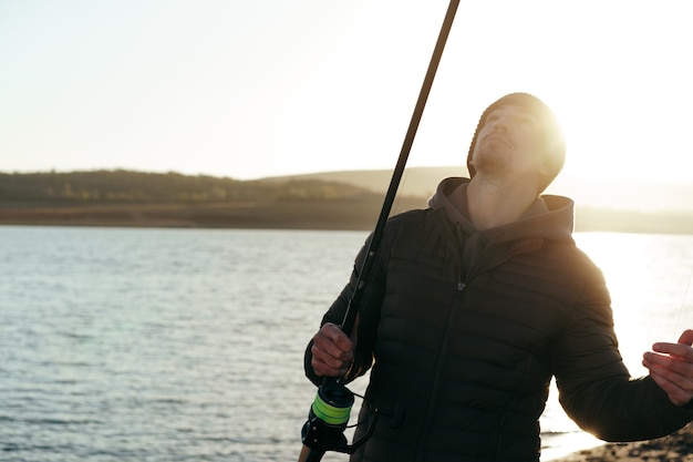 日の出の湖で釣りをする男性の漁師