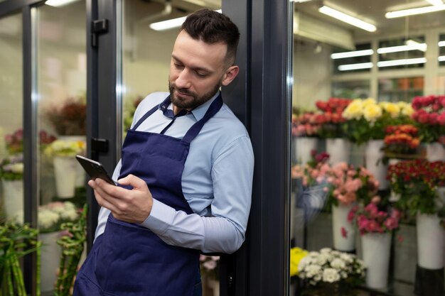 Male florist during break sourcefed internet for phone