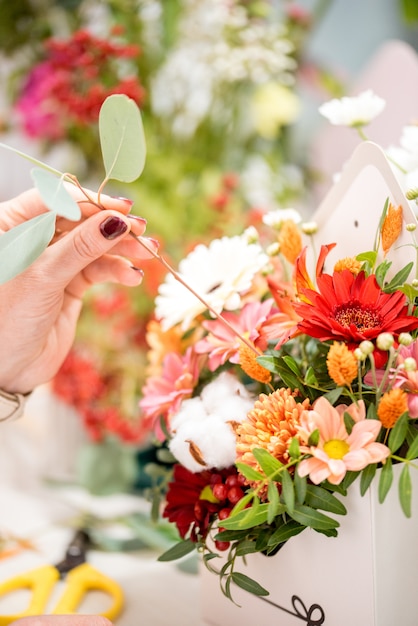 Foto fiorista maschio che crea bello mazzo nel negozio di fiore, fine su