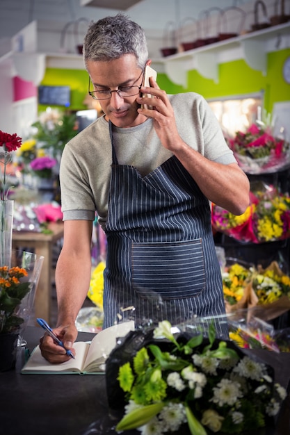 Male florist taking order on mobile phone