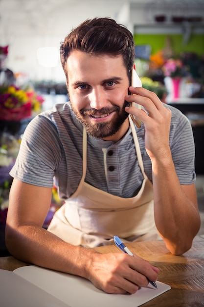 Male florist talking on mobile phone