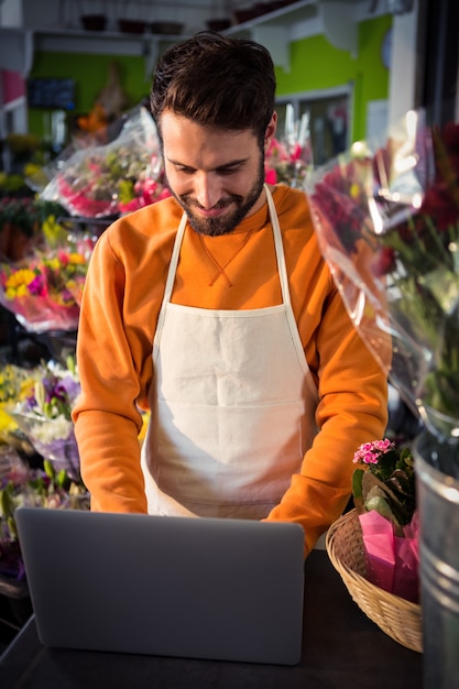 Male florist working on laptop