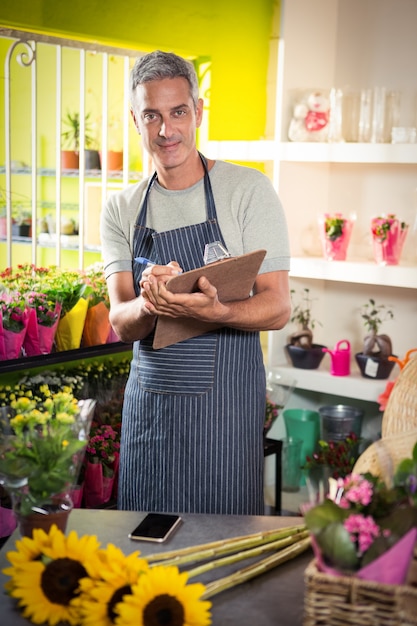 Male florist writing on clipboard