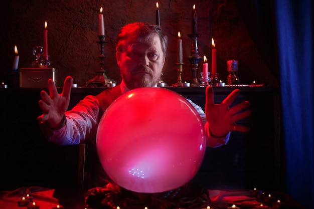 Male fortune teller with illuminated crystal ball