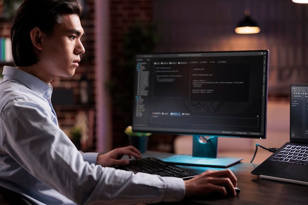 Libero professionista maschio che sviluppa software app sul computer, lavorando con un programma di codice binario per creare un server di sicurezza firewall. programmazione del codice dell'applicazione con il cloud computing su interfaccia high tech.