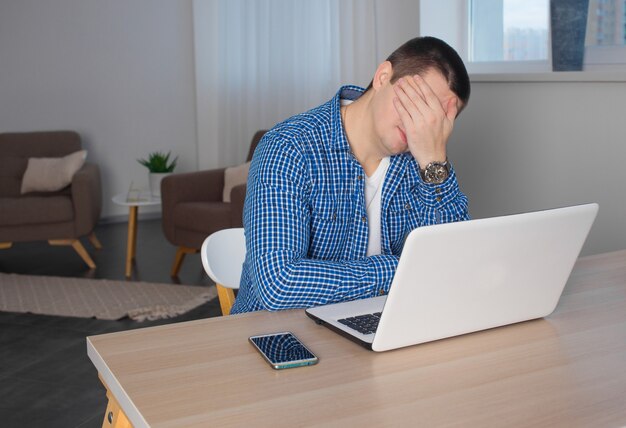 Libero professionista maschio sta lavorando con un laptop a casa. concetto di lavoro a distanza