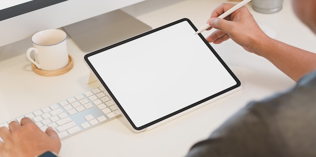 Male freelancer using blank screen tablet in comfortable workplace 