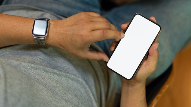 Male freelancer using smart mobile phone relaxing while using mobile app Phone blank screen mockup