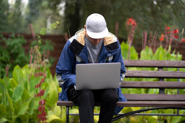 Male freelancer working outdoors using laptop wireless technology