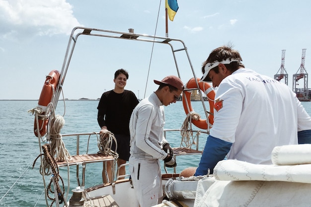 Foto amici maschi su una nave nautica in mare