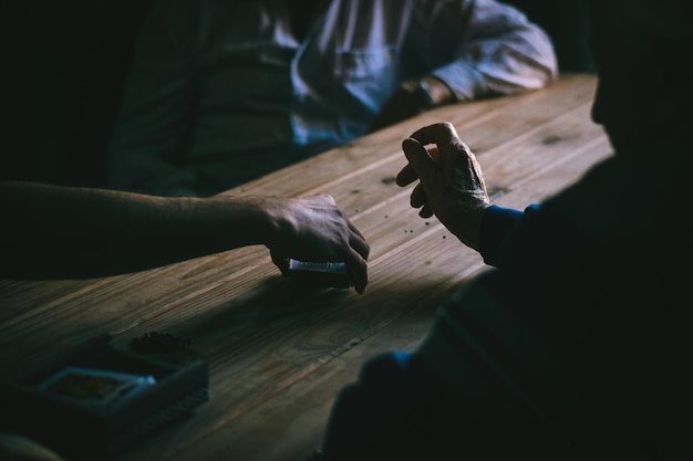 male friends playing cards on wooden table