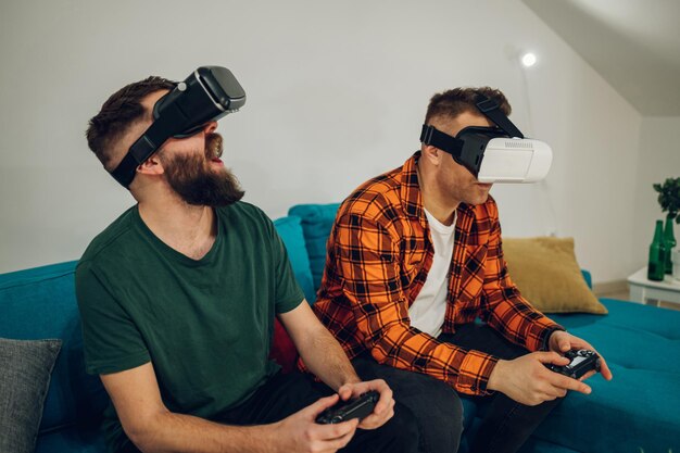 Photo male friends playing video games on a virtual reality glasses at home