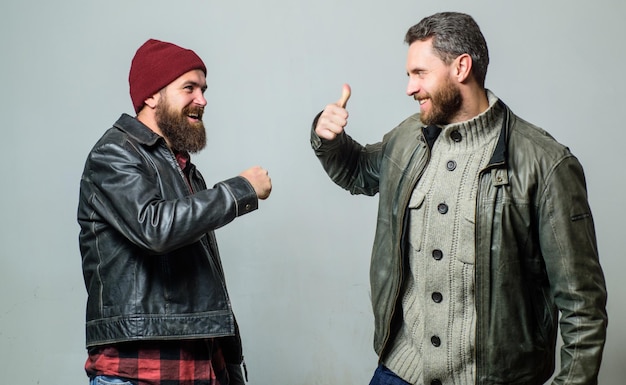 Male friendship concept Brutal bearded men wear leather jackets Real men and brotherhood Friends glad see each other Friendly relations Friendship of brutal guys Real friendship mature friends